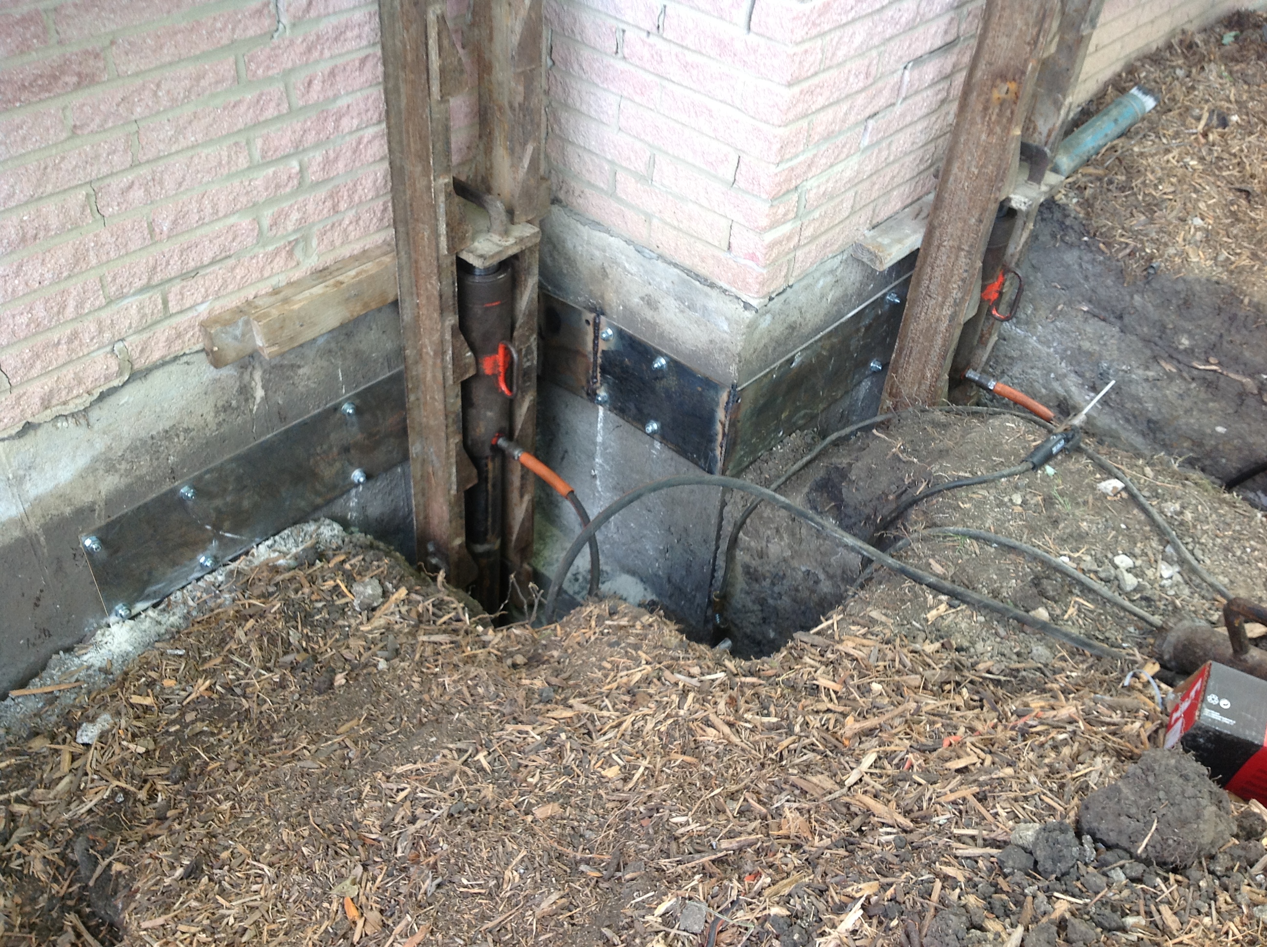 Steel support bracket installed at an exposed foundation corner