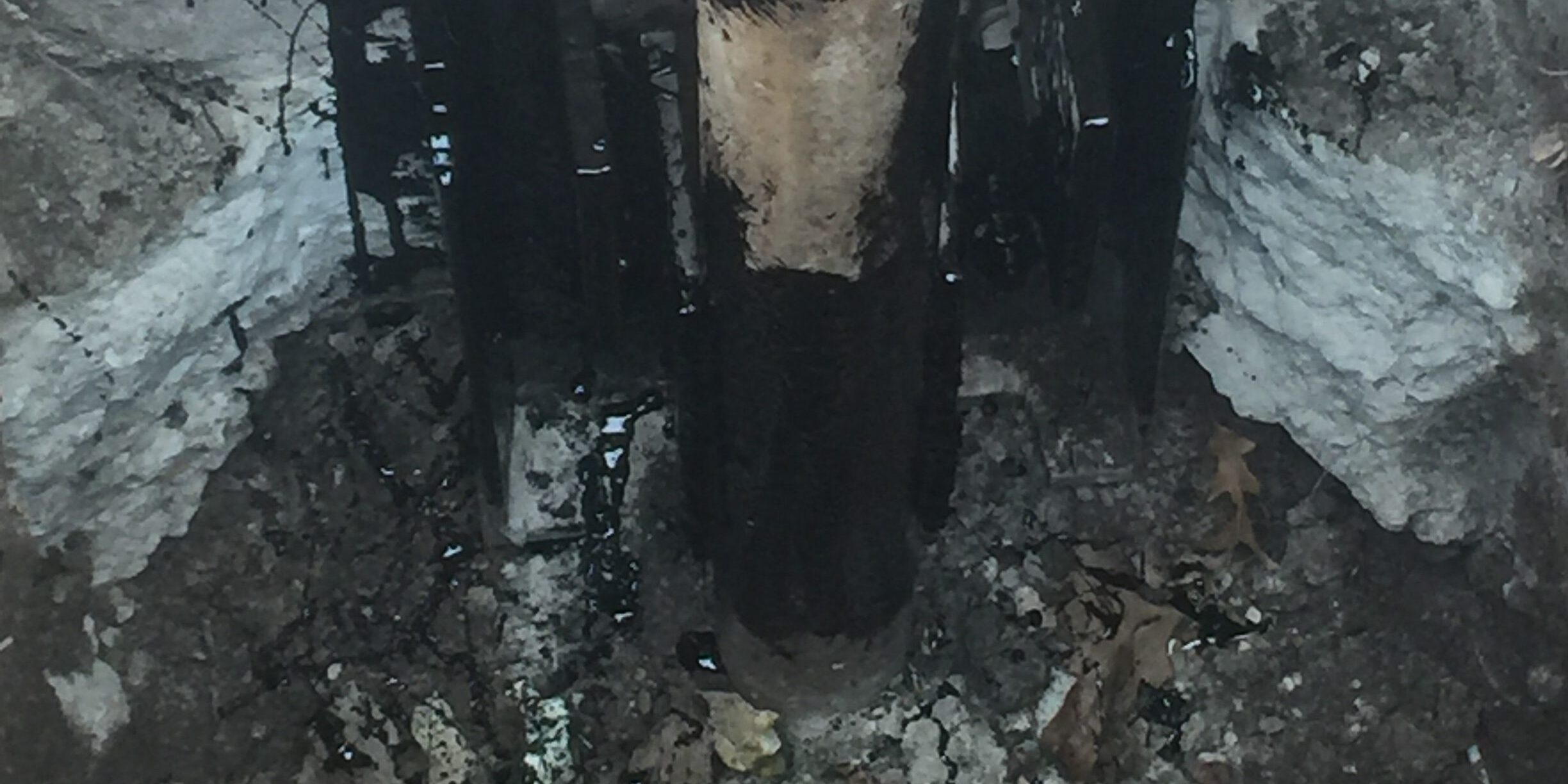 Steel push pier and foundation support bracket installed beneath a concrete foundation